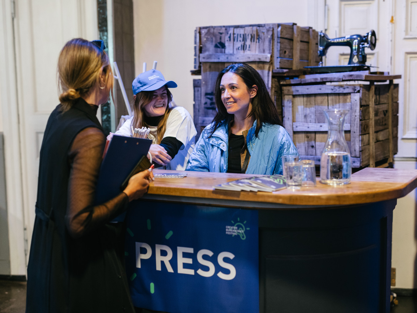 press counter at the festival, 3 woman having a conversation