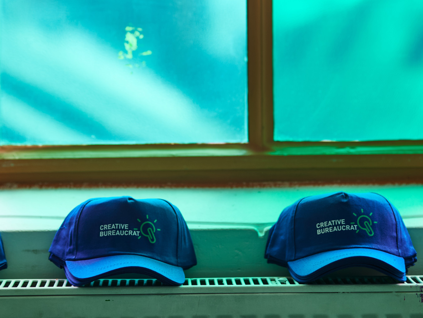 creative bureaucracy festival merch (4 caps) on a heater