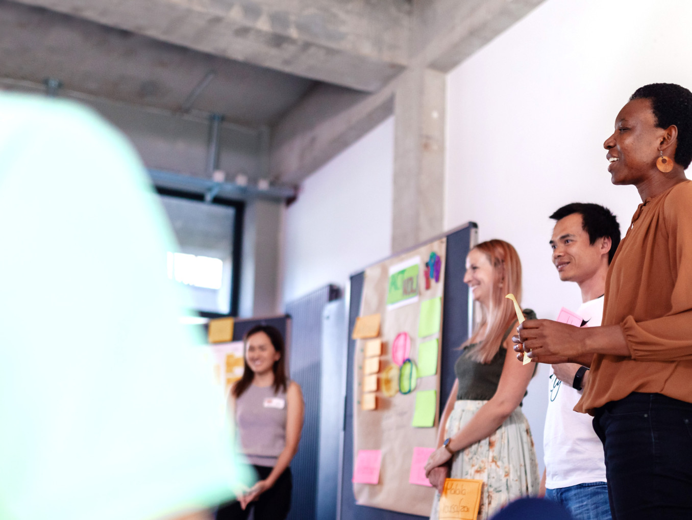 A group of people standing in front of the room and holding a presentation.