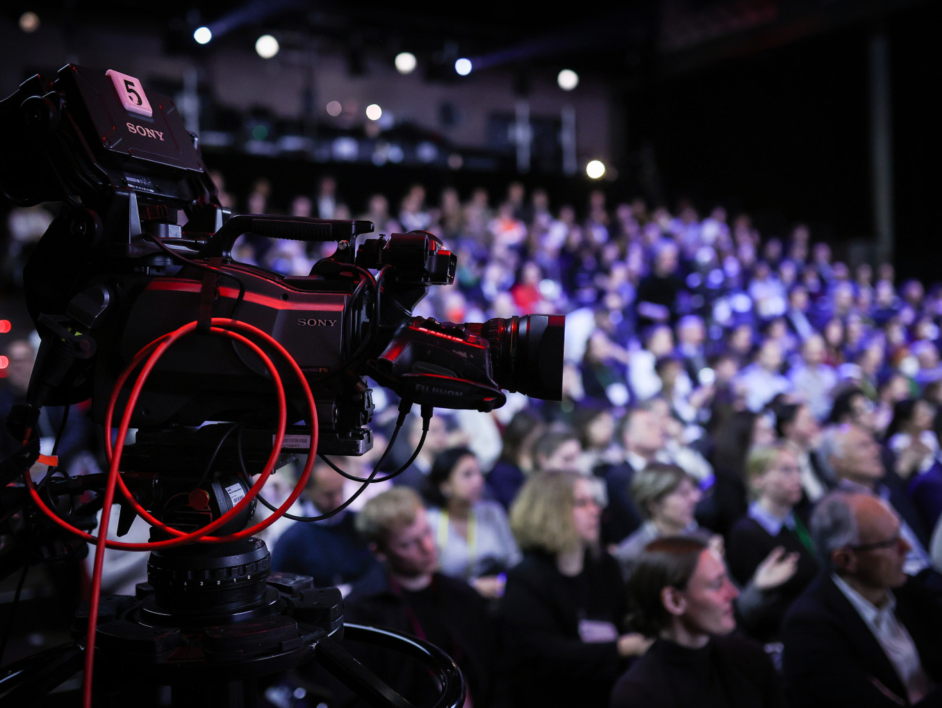 Camera recording a presentation at Falling Walls Science Summit 2023, with the audience in the background