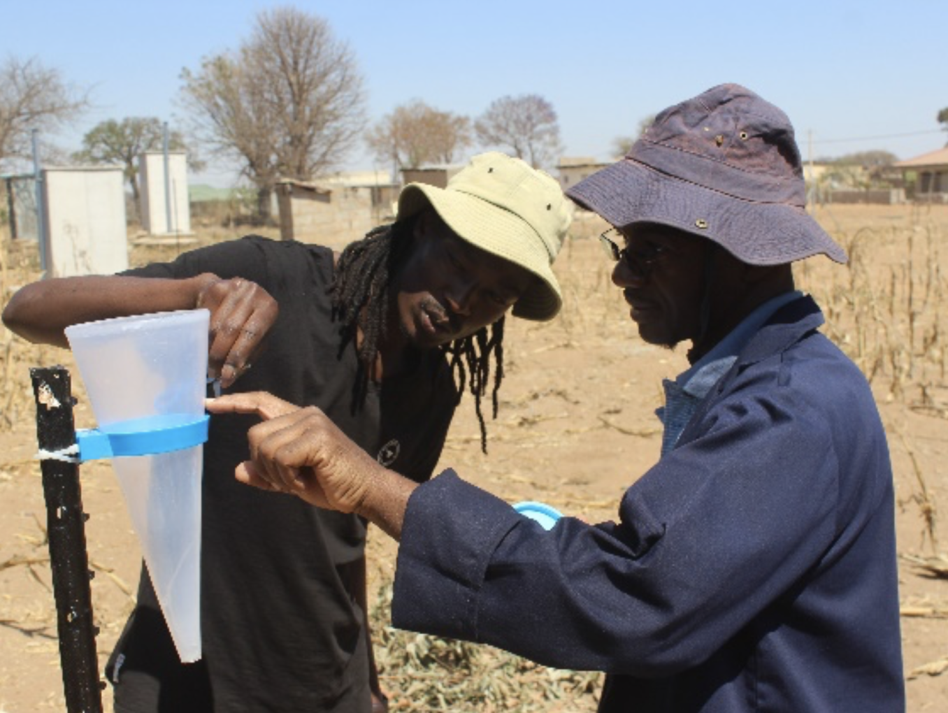 two men in desert measuring water