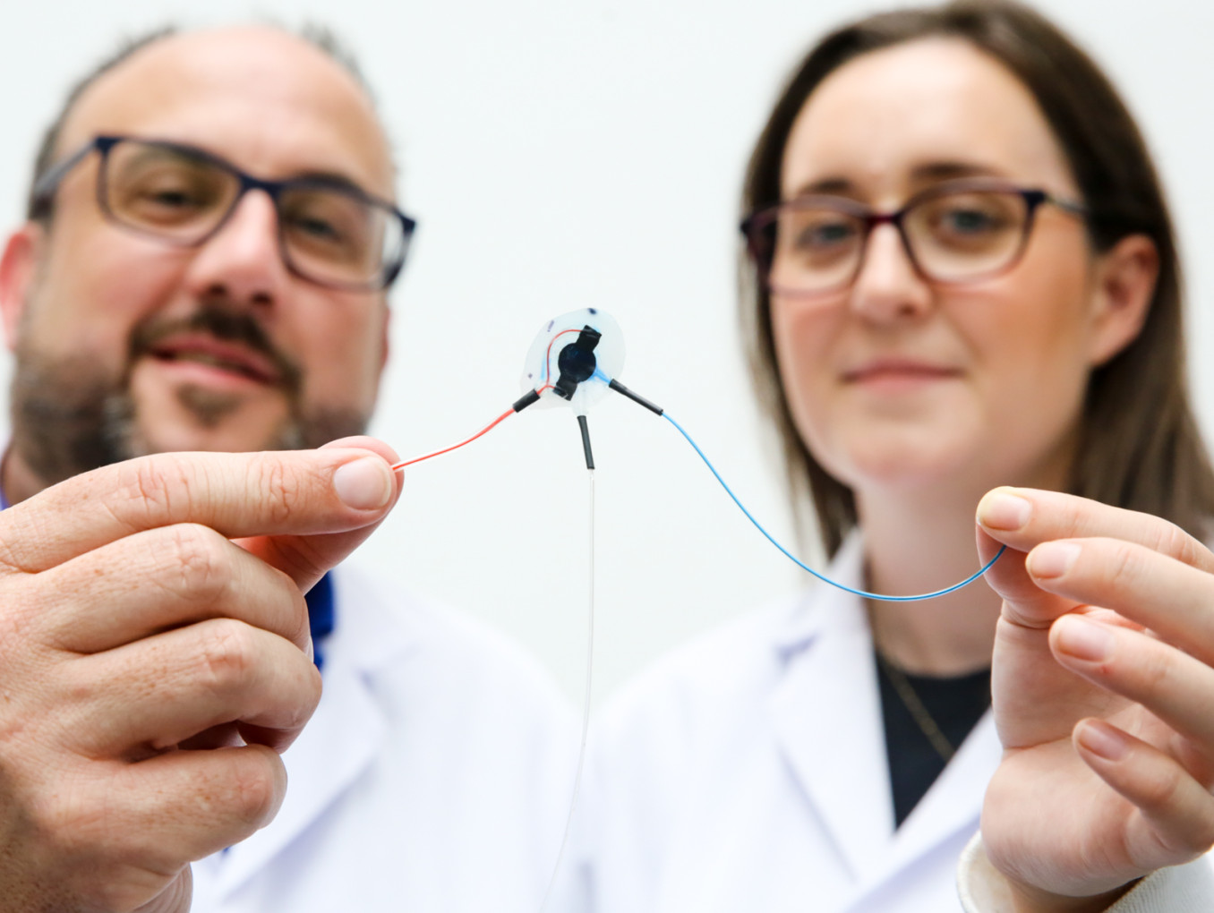 Duffy and Beaty holding early prototype of soft robotic drug delivery device