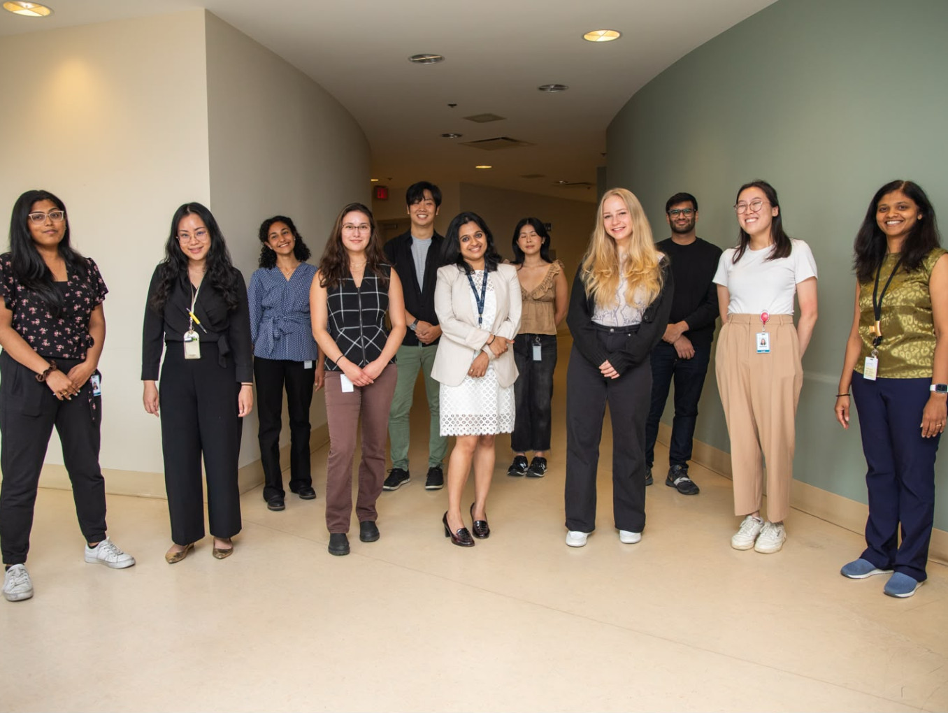 A group of people (11) standing in a hallway, looking professional