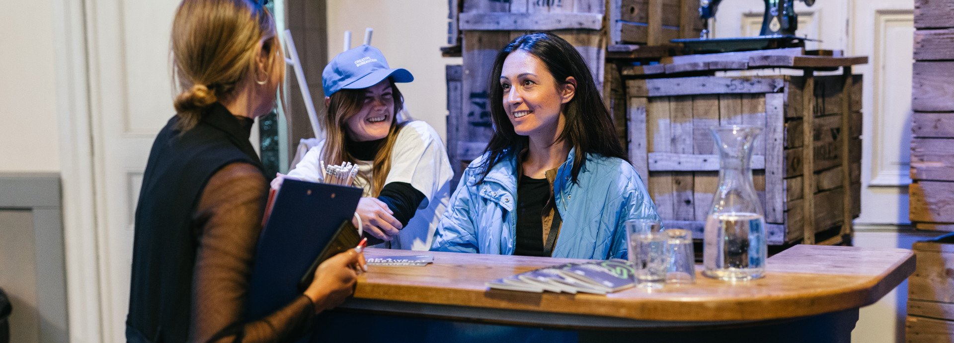 press counter at the festival, 3 woman having a conversation