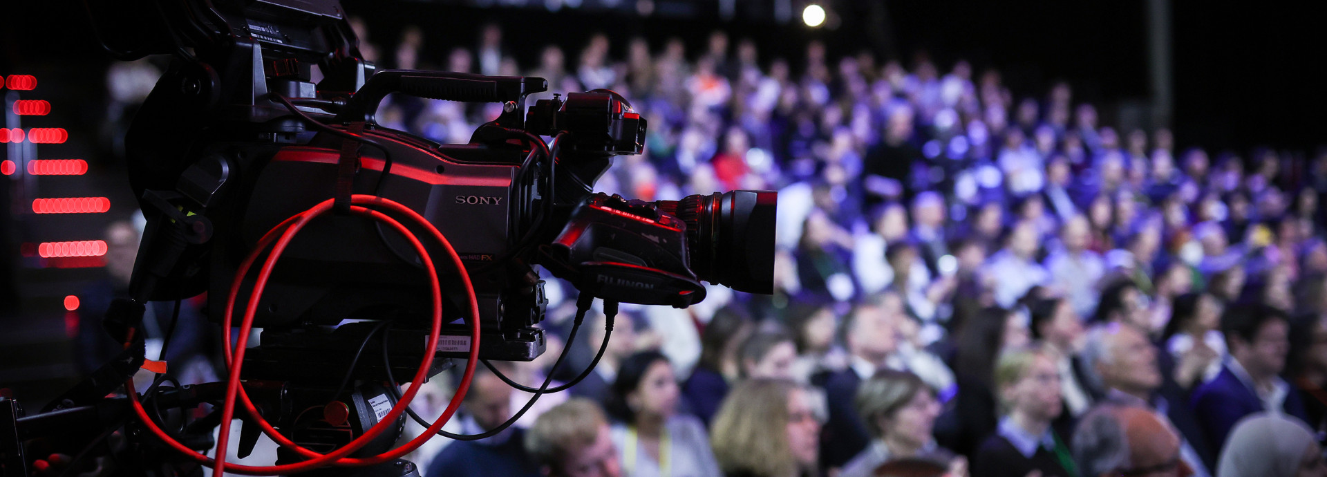 Camera recording a presentation at Falling Walls Science Summit 2023, with the audience in the background