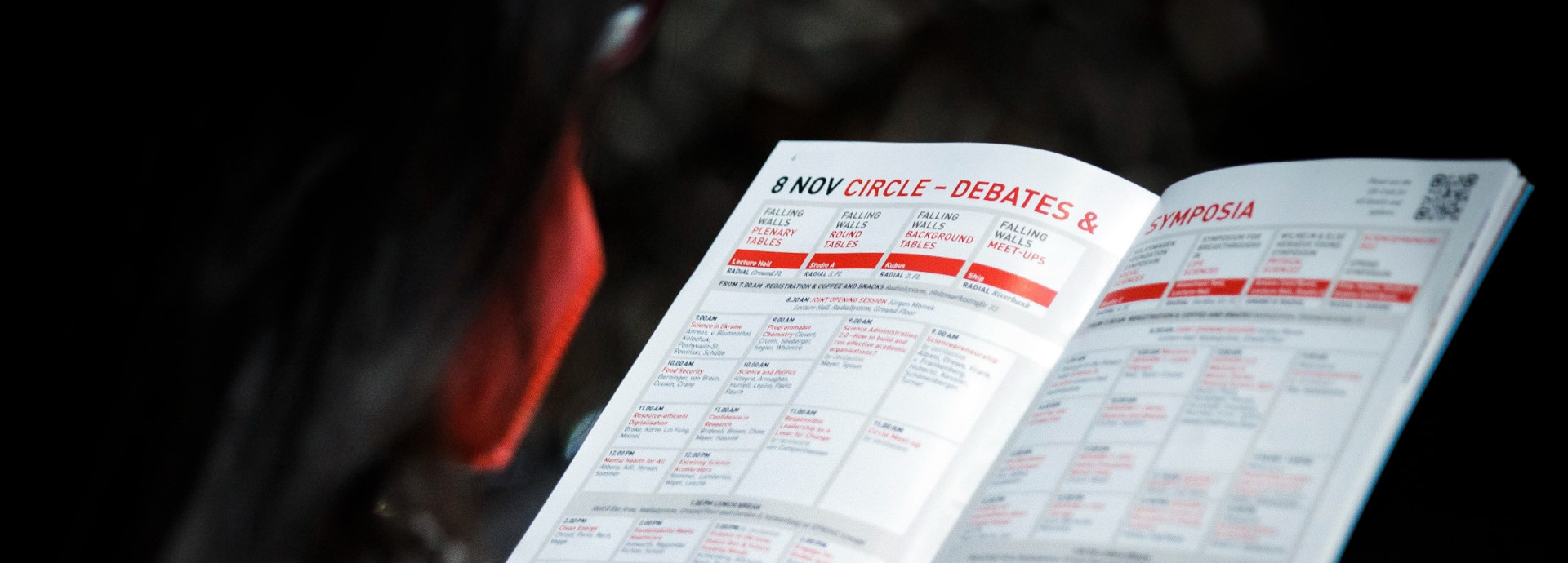Picture of someone holding the printed Programme of the Science Summit 2022