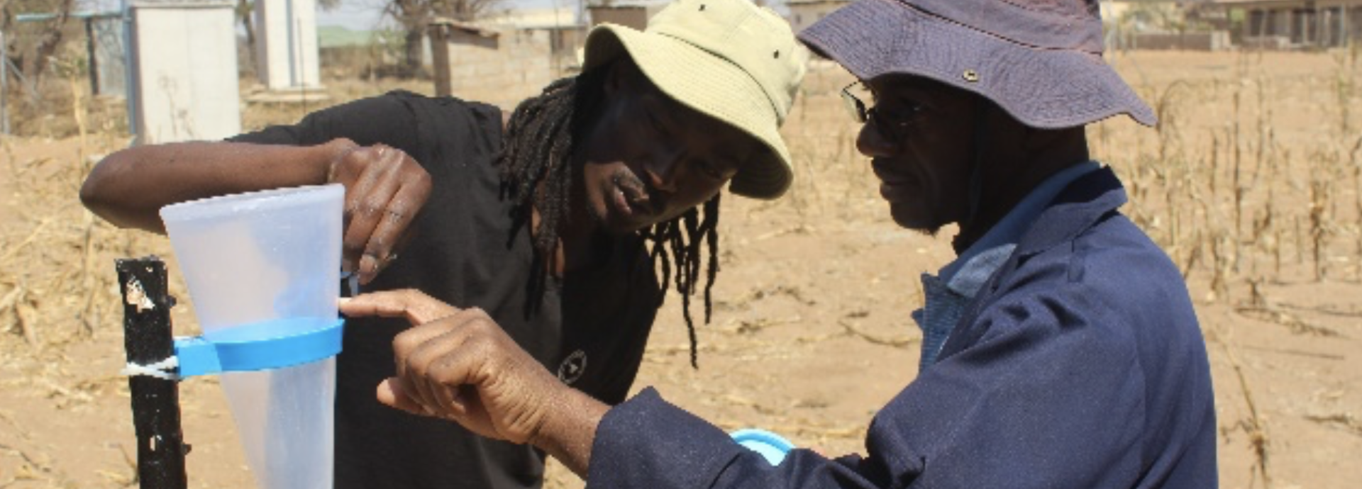 two men in desert measuring water