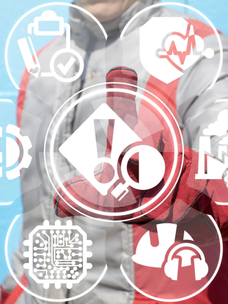 A person in a grey and red jacket and gloves reaches out towards a central, large icon depicting a magnifying glass over a document with an exclamation point. Around this central icon, smaller white circular icons are arranged: a clipboard with a checkmark, a heartbeat line, a factory with smoke, a hard hat with headphones, and an eye. The background is a solid light blue.