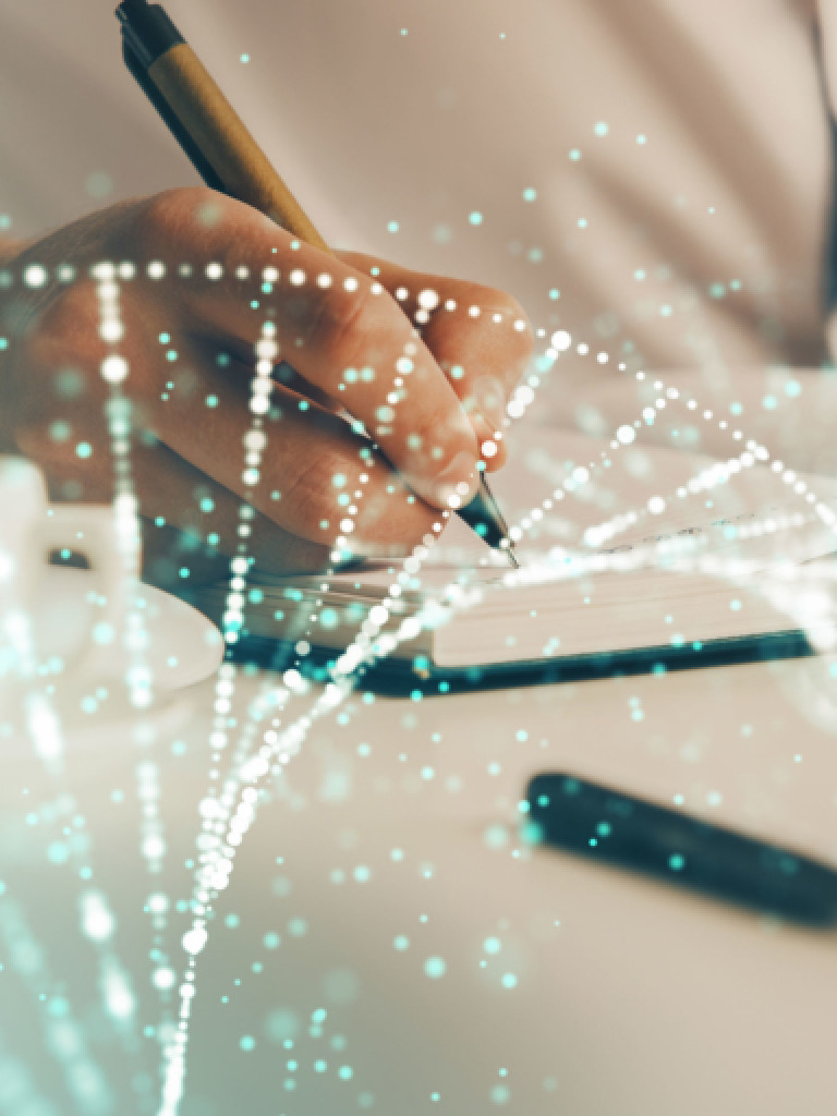 A close-up of a person's hand, wearing a white shirt, writing in a notebook with a pen. A white coffee cup is visible to the left. Overlaid on the image is a translucent, glowing double helix structure, representing DNA, with numerous small dots forming its strands. The overall impression is one of science, research, or biotechnology.