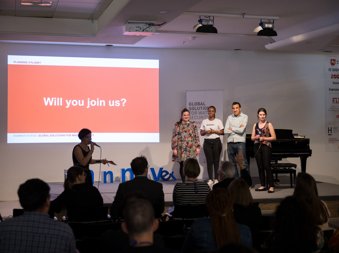 Group presenting at Falling Walls Summer School 2023. "Will you join us?" on a Screen.