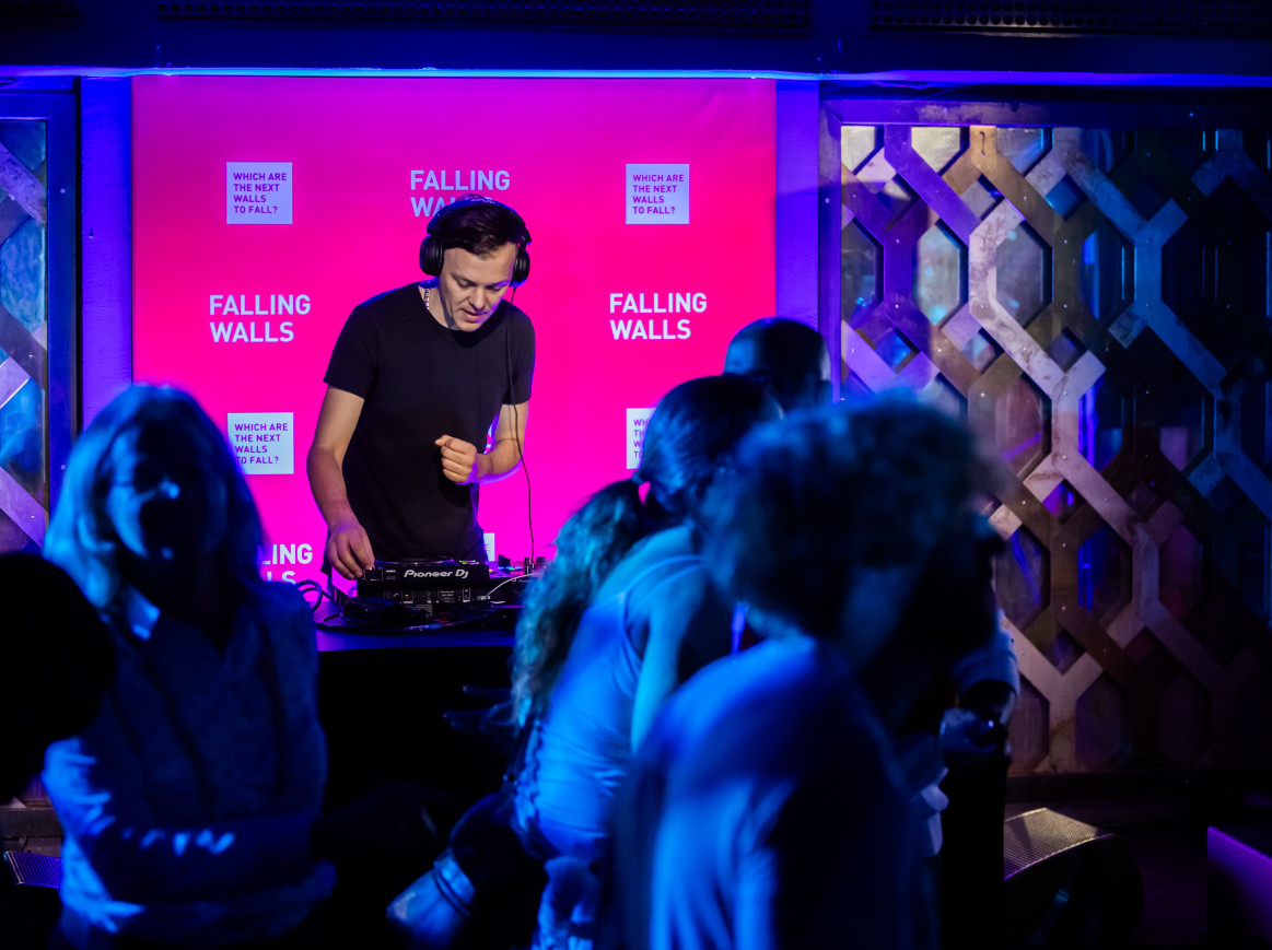DJ playing in front of a dancing crowd