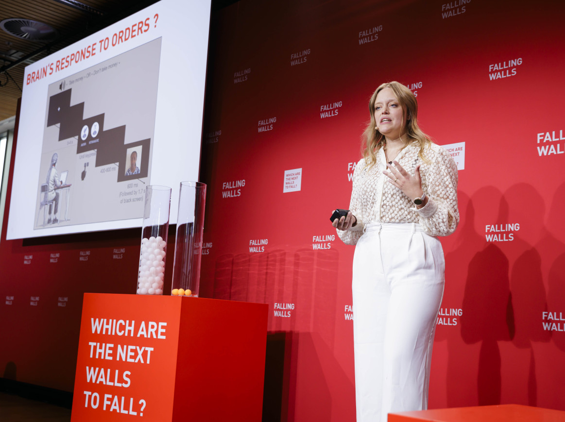 Emilie Caspar breaking the wall of blind obedience on stage at Science Summit 2024
