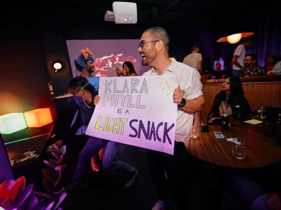 an audience member brings homemade signs to cheer on their favourite performer