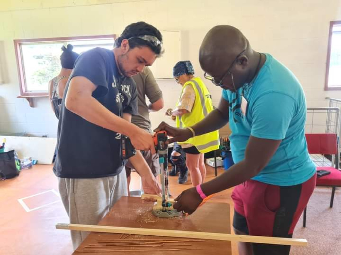 Thabiso Mashaba is processing wood together with a participant.