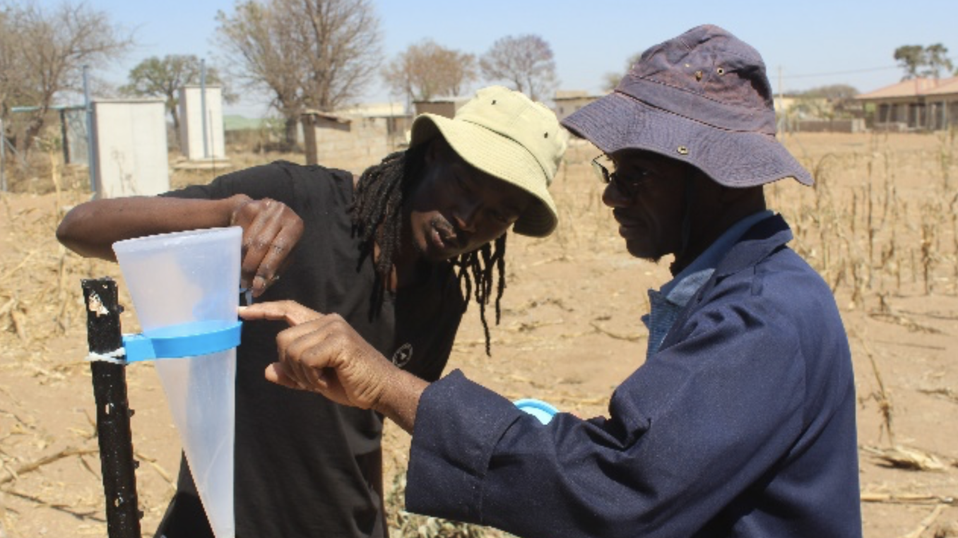 two men in desert measuring water