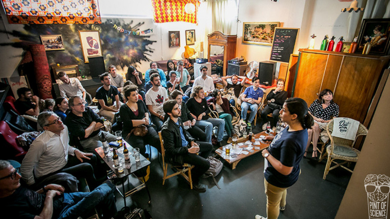 A person is presenting in front of people at bar