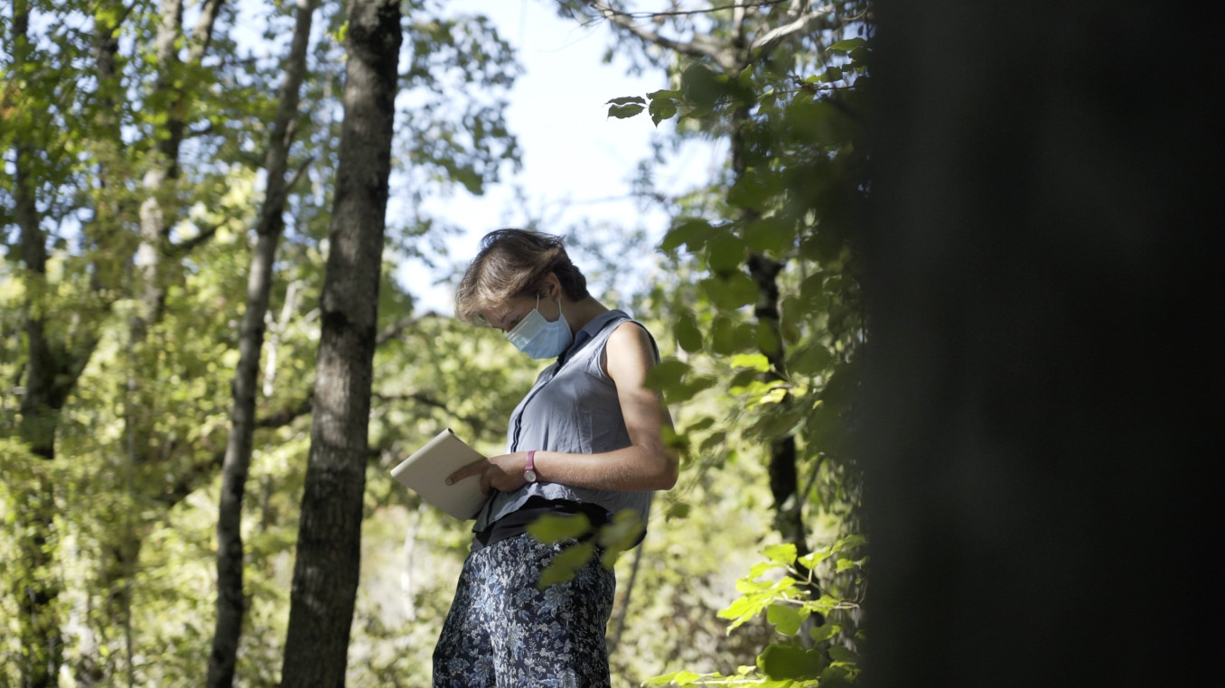 Anna Berti Suman is writing notes in woods
